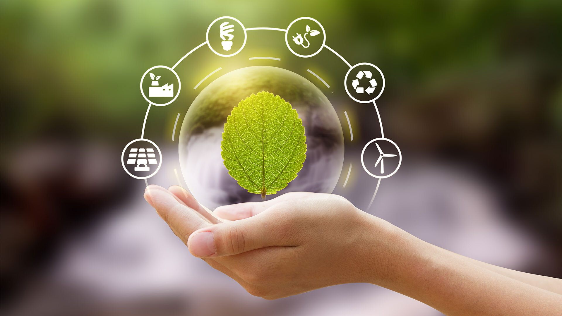 Hand holding a green leaf with eco-friendly icons, symbolizing sustainability and renewable energy