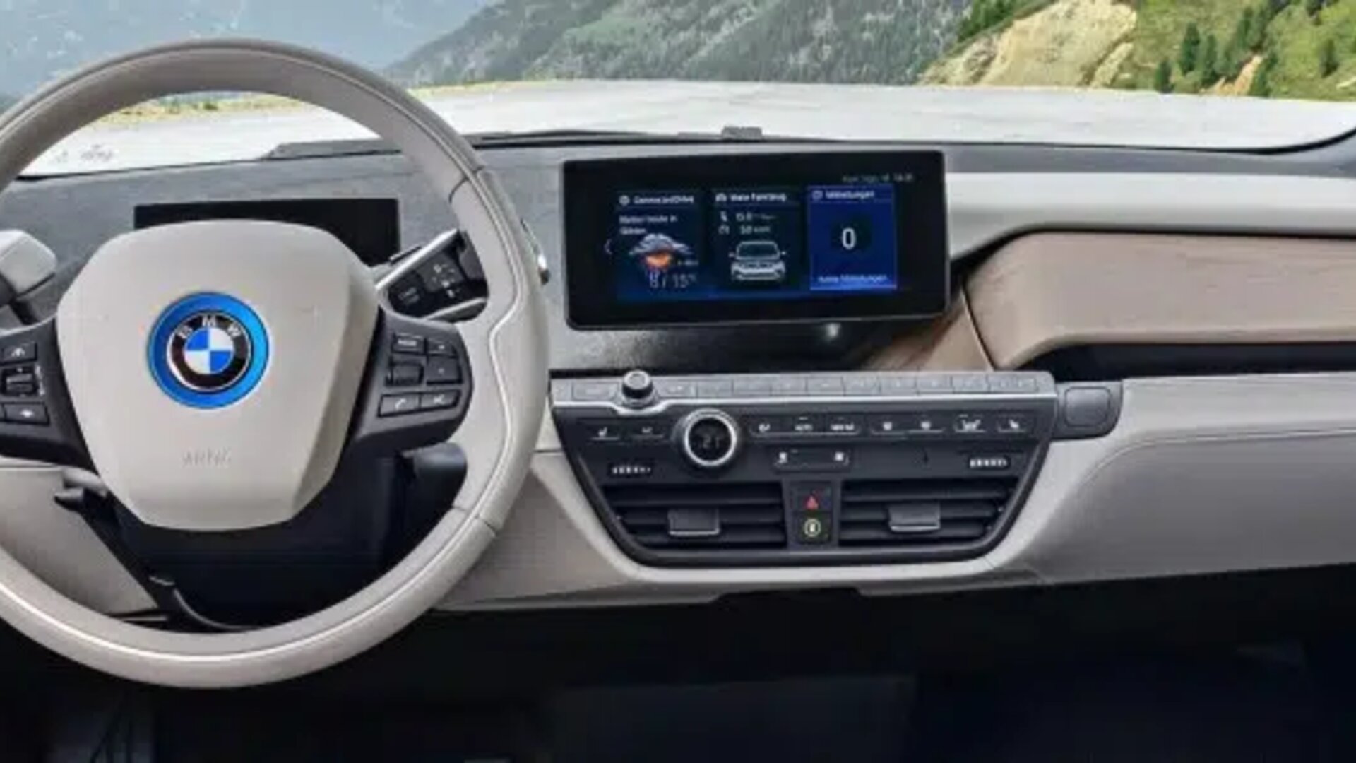 BMW i3 interior with steering wheel, dashboard, digital display, and mountain views